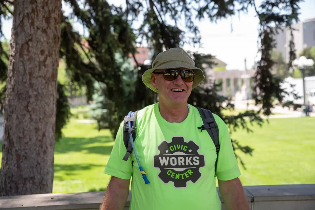 Civic Center WORKS site lead Kevin at the park, smiling in sunglasses and hat.